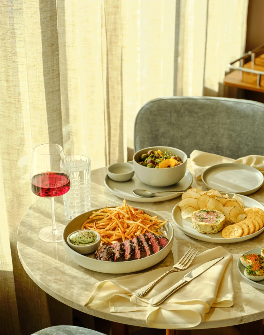 Steak frites, snacks and a glass of rosé on the marble tables at High Ground Lounge